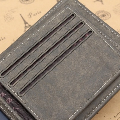 Carteira masculina cinza com ranhuras para cartões sobre fundo com desenhos de Paris