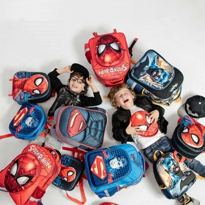 Mochilas infantis com temas de super-heróis e duas crianças brincando em fundo branco