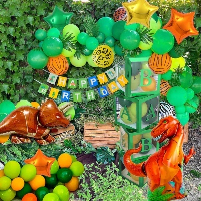 Decoração colorida de festa infantil com balões de dinossauros e blocos de letras