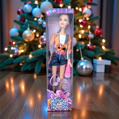 Boneca KPOP DEMON HUNTERS na caixa com acessórios rosa em frente a árvore de Natal