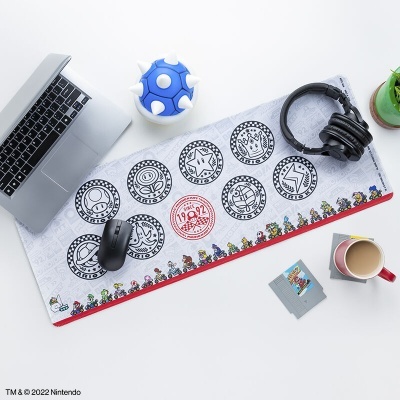 Tapete de rato Nintendo branco com círculos pretos e borda vermelha numa mesa com portátil, auscultadores, rato, caneca e planta