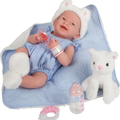 Boneco bebé silicone com roupa azul e acessórios rosa e branco numa manta azul.