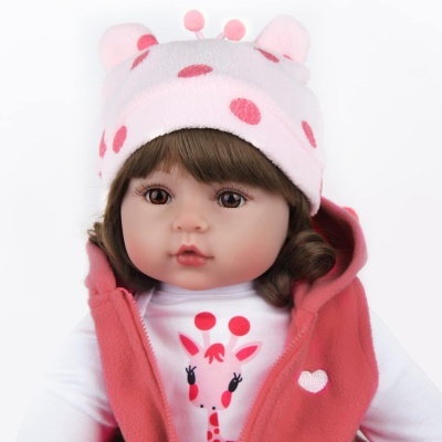 Boneca vestida com roupa branca, colete rosa e chapéu rosa com bolinhas vermelhas