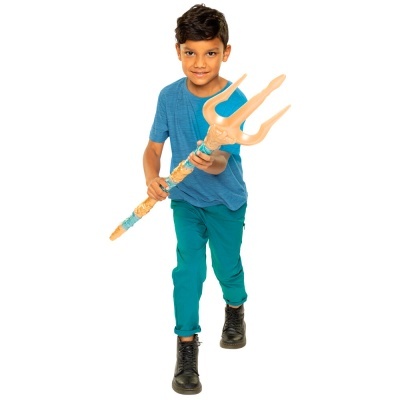 Menino com tridente de plástico e roupa azul contra fundo branco