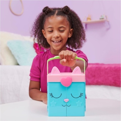Mala infantil em forma de gato azul e rosa nas mãos de menina sorridente