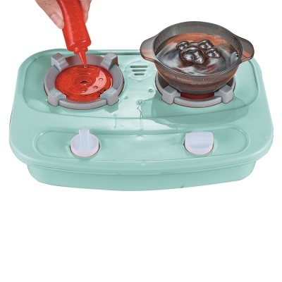 Fogão de brinquedo verde claro com dois queimadores e panela com tampa de vidro