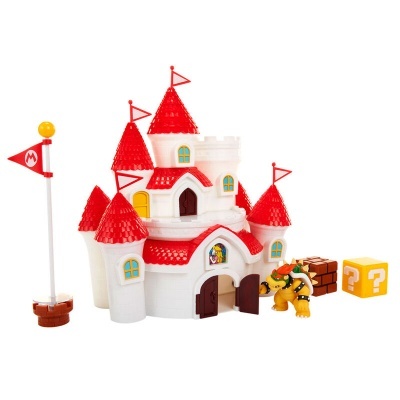 Castelo de brinquedo branco com telhados vermelhos, figura de dragão e blocos coloridos ao lado