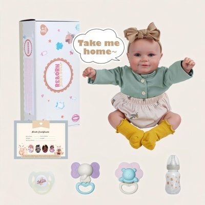 Boneca tipo recém-nascido com roupa verde e bege, com caixa, certificado, chupetas e biberão