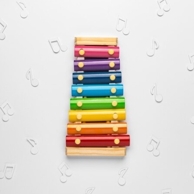 Xilofone infantil colorido de madeira com notas musicais ao fundo