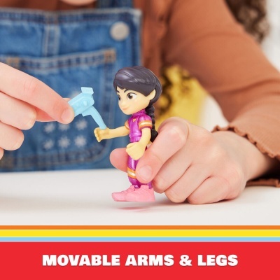 Boneco de plástico com braços e pernas móveis, roupa rosa, segurado por mãos infantis.