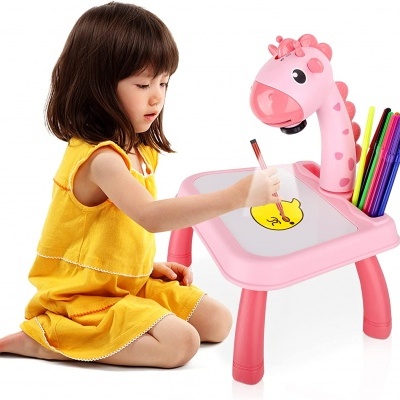 Criança a desenhar numa mesa infantil rosa com projetor em forma de girafa