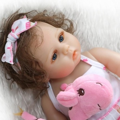 Boneca realista com vestido rosa e faixa de cabelo