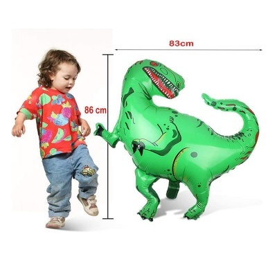 Balão dinossauro verde insuflável ao lado de criança