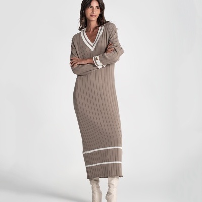 Mulher a usar vestido longo de malha castanha clara com riscas brancas e botas brancas