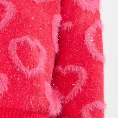 Camisola vermelha felpuda com corações cor-de-rosa e fios brilhantes prateados.