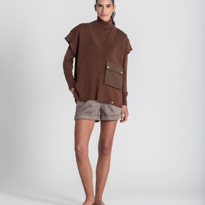 Mulher com roupa castanha e calções num fundo branco