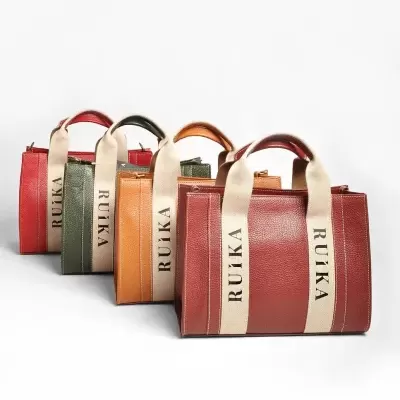 Malas de pele em várias cores com alças de tecido bege e inscrições RUÍKA