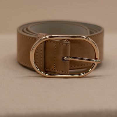 Cinto bege com fivela oval dourada colocado enrolado