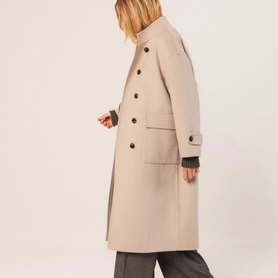 Casaco comprido bege com botões negros e bolso lateral