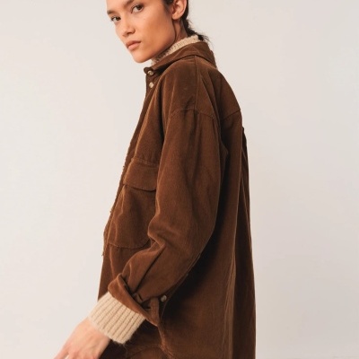 Casaco oversized castanho de veludo com gola alta e botões dourados, punhos de malha castanha clara.