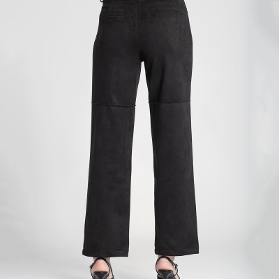 Calças pretas largas com detalhes de costura, vistas de trás, usadas com sandálias pretas de salto alto.