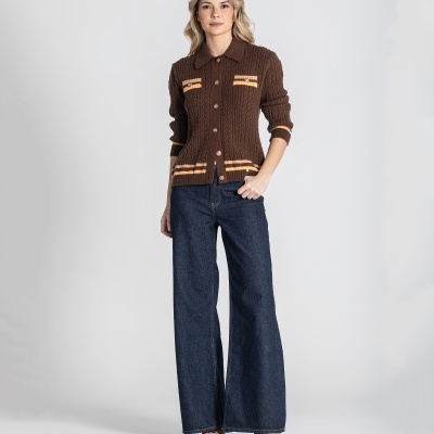 Mulher a usar cardigã castanho trançado com riscas amarelas, calças de ganga largas e sandálias castanhas