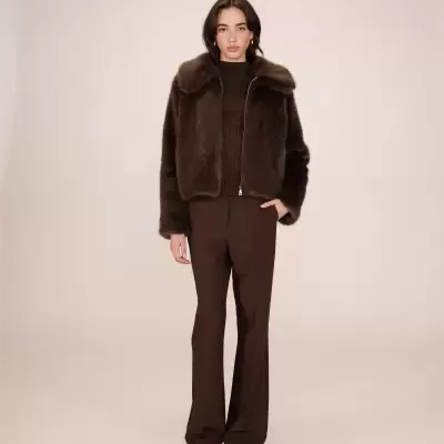 Mulher com casaco de pelo castanho e calças castanhas