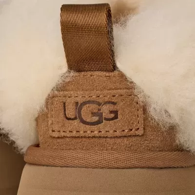 Calçado tipo bota UGG castanho claro com interior de lã felpuda e etiqueta logo UGG