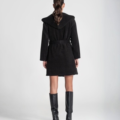 Mulher vestindo casaco preto felpudo com capuz e botas pretas altas vista de costas