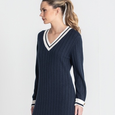 Vestido de malha azul escuro com gola em V e punhos brancos com riscas azuis.
