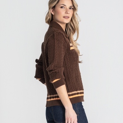 Mulher com camisola castanha de malha grossa e calças de ganga azul escuro