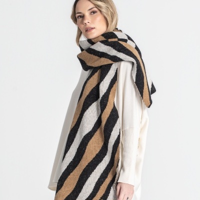 Lenço grosso listrado em preto, branco e castanho usado por mulher com camisola branca