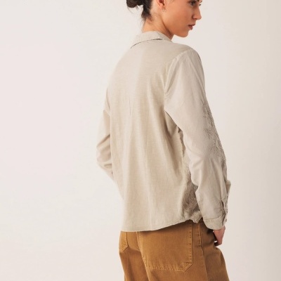 Camisola bege clara de manga comprida vista de costas com calças castanhas