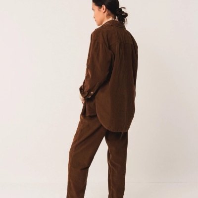 Pessoa de costas com conjunto castanho de camisa e calças