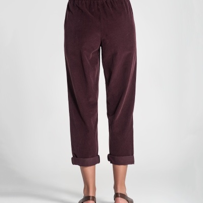 Calças de veludo bordô com elástico e bainha arregaçada vistas de costas