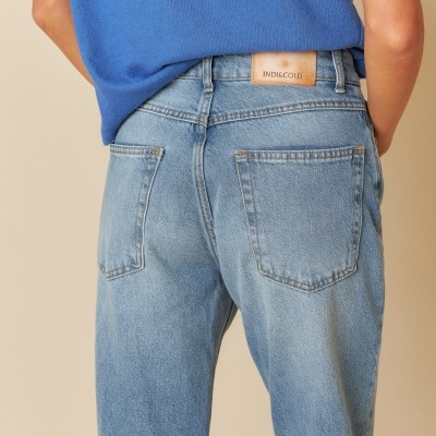 modelo de costas a usar calças de ganga azul claro com etiqueta INDIE COLD e t-shirt azul