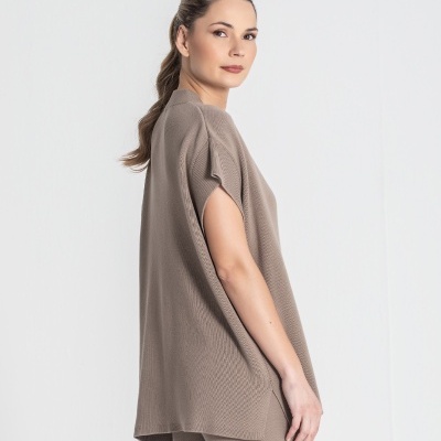 Mulher com túnica e calças castanhas claras de malha