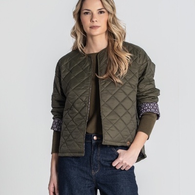 Casaco acolchoado verde musgo com padrão de losangos e gola redonda, usado por mulher