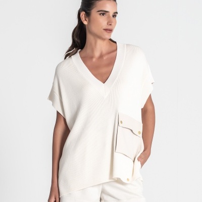 Mulher com colete branco e calções brancos sobre fundo branco