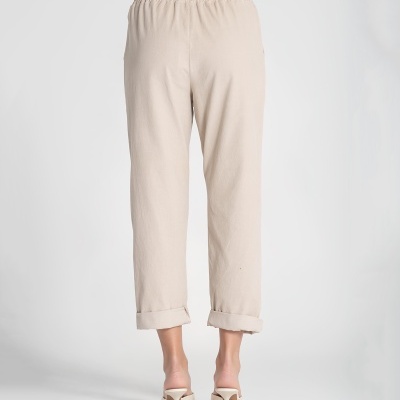 Calças compridas bege claro com bainhas dobradas e cós elástico vistas de costas