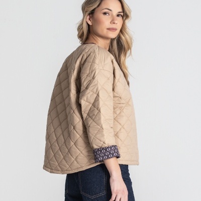 Casaco bege acolchoado com padrão de losangos e punho geométrico roxo