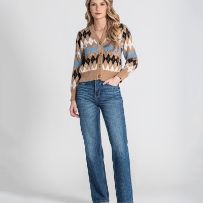 Mulher vestindo casaco de malha com padrão de losangos e jeans azul