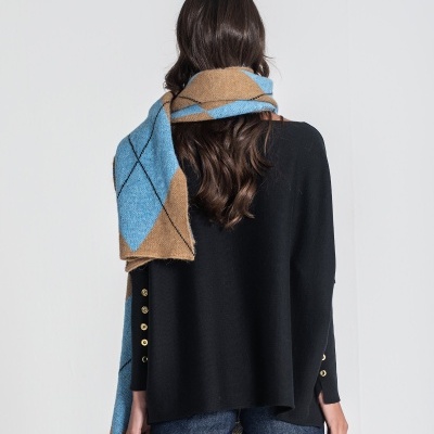 Mulher de costas com cachecol azul e castanho, suéter preto e calças de ganga