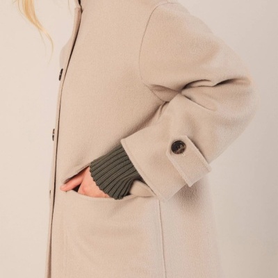 Casaco bege de lã com botão escuro e bolso, punho verde de malha