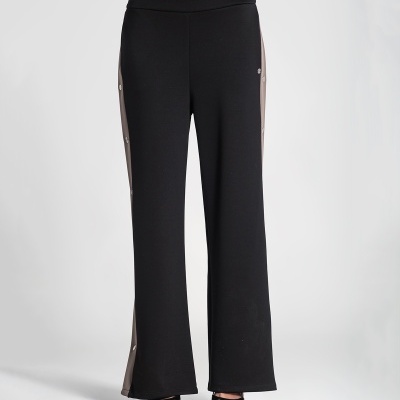 Calças pretas com faixa lateral cinza e botões prateados, usadas com sapatos pretos.