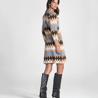 Vestido de malha com padrão geométrico em tons castanho, azul, branco e preto com botas pretas de cano alto
