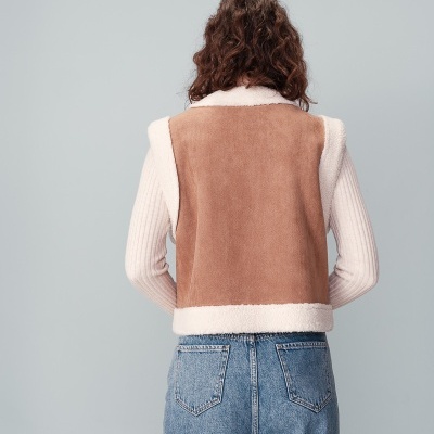 Colete castanho claro com bordas em pelo branco visto de costas