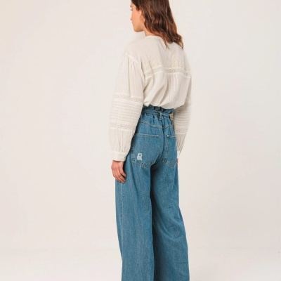 Calças de ganga largas com camisa branca bordada em fundo branco