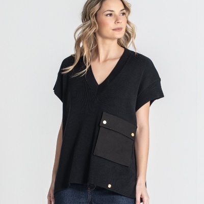 Mulher com camisola preta de malha com bolso e calça jeans azul escura, fundo branco