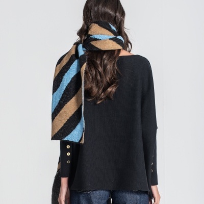 Pessoa de costas com camisola preta, echarpe riscada castanho e azul, e jeans azuis